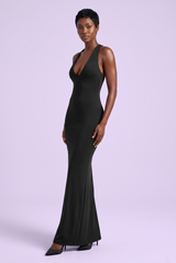 Vestido comprido preto justo, com decote profundo, costas descobertas e luvas