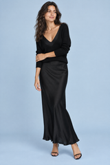 Vestido maxi de cetim preto com decote assimétrico e detalhes de penas
