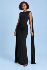 Vestido comprido preto justo com decote barco, mangas-capa e costas abertas